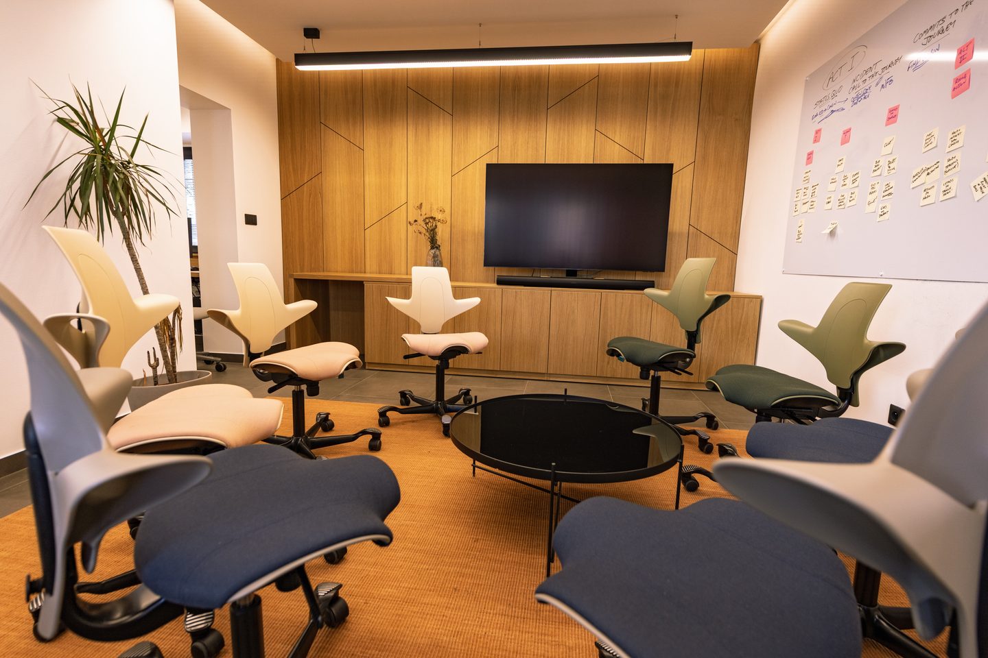 Lounge přestavěný na kruh osmi židlí čelem k obrazovce a popisovatelné stěně